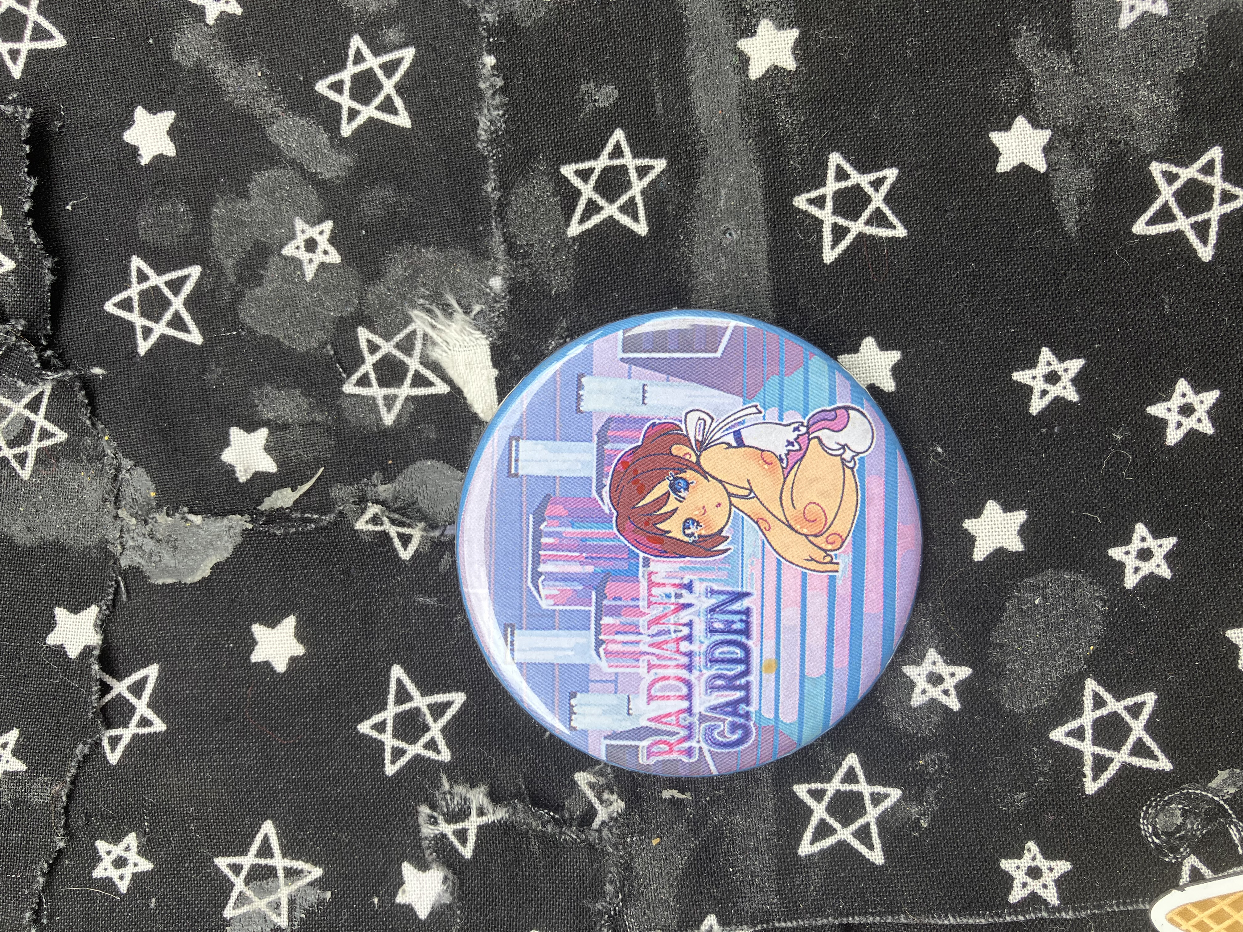 Button of Kingdom hearts kid Kairi sitting near fountains and the words Radiant Gardens.